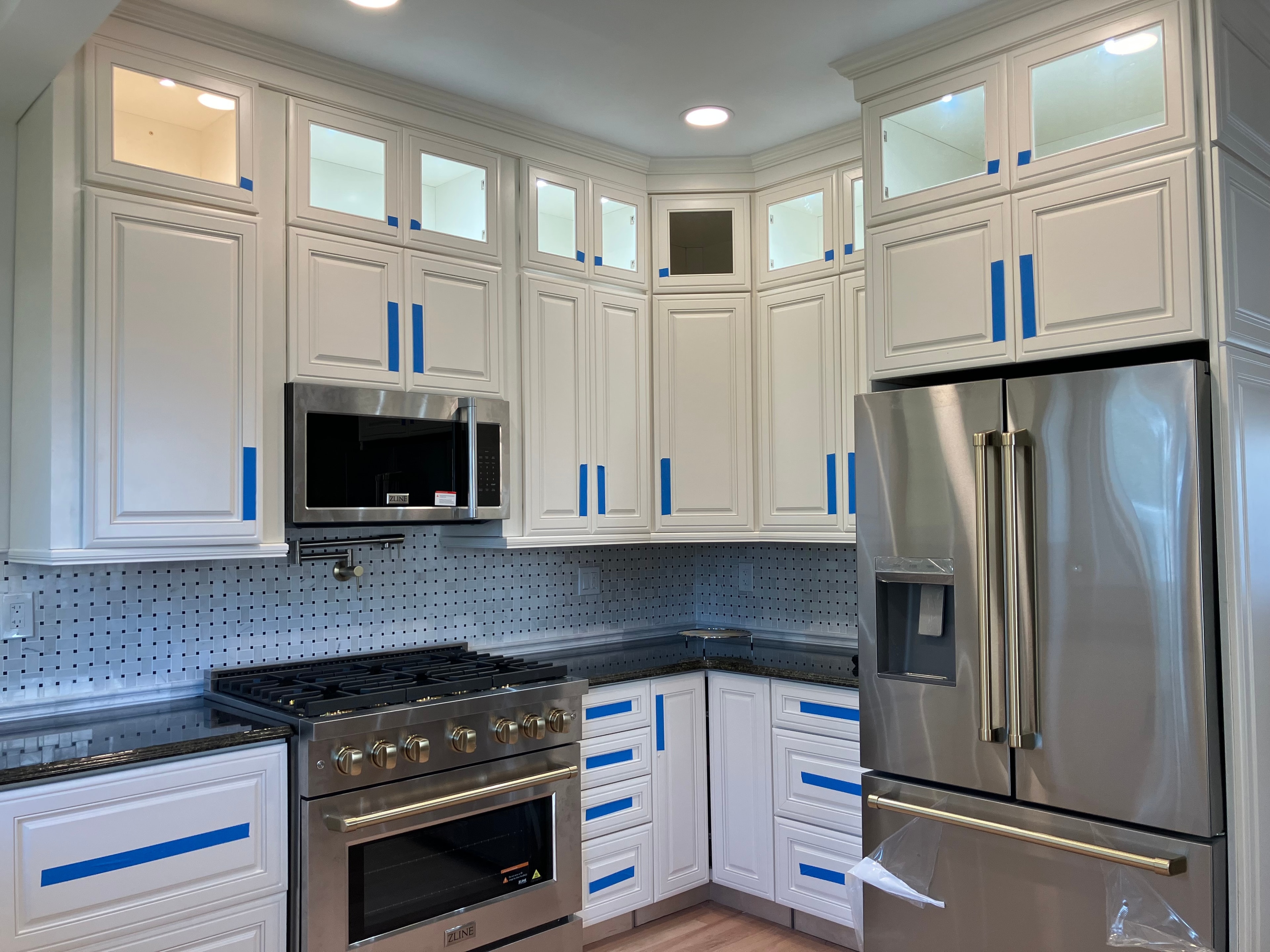 Bright kitchen with white shaker cabinets, subway tile backsplash, and modern pendant lighting
