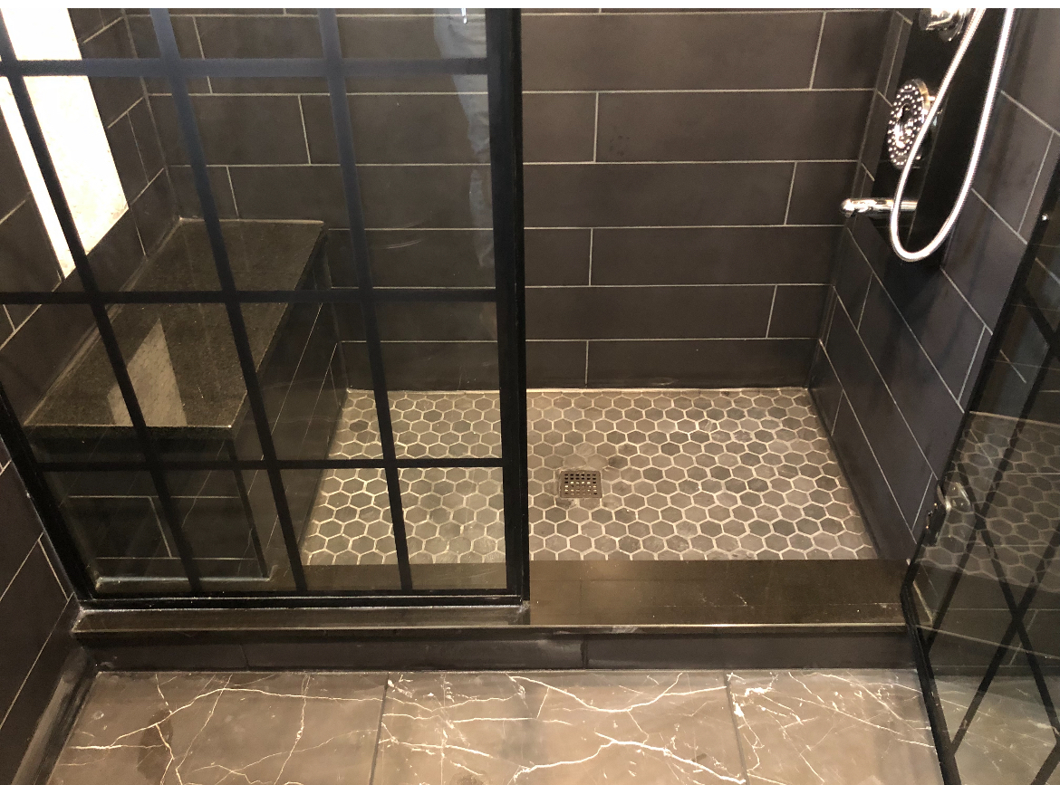 Modern bath with brass hardware and sconce lighting